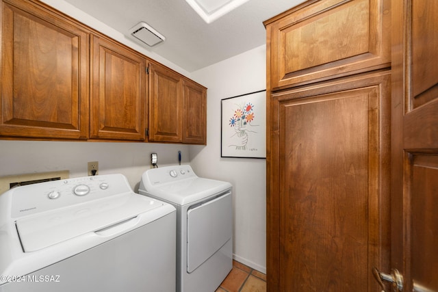 clothes washing area featuring washer and dryer, cabinet space, and visible vents