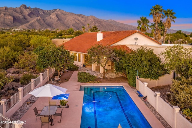 view of swimming pool featuring a patio area, a fenced in pool, a mountain view, and a fenced backyard