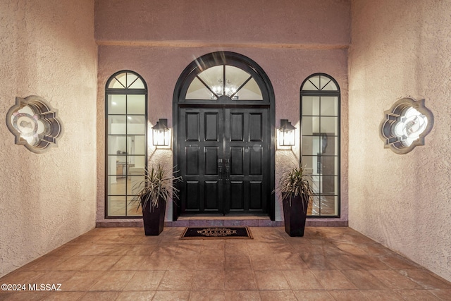 doorway to property featuring stucco siding