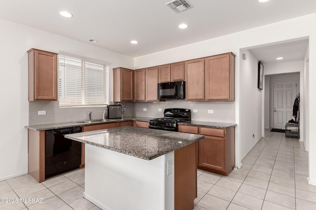 kitchen with tasteful backsplash, sink, a kitchen island, and black appliances