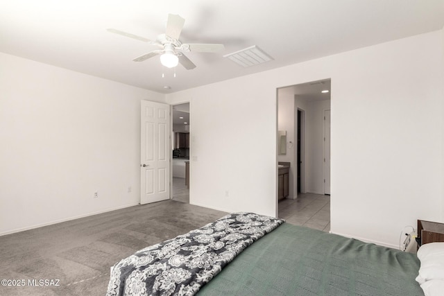 carpeted bedroom featuring ceiling fan and ensuite bath