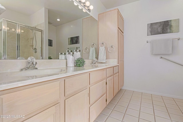 bathroom with a sink, double vanity, a shower stall, and tile patterned floors