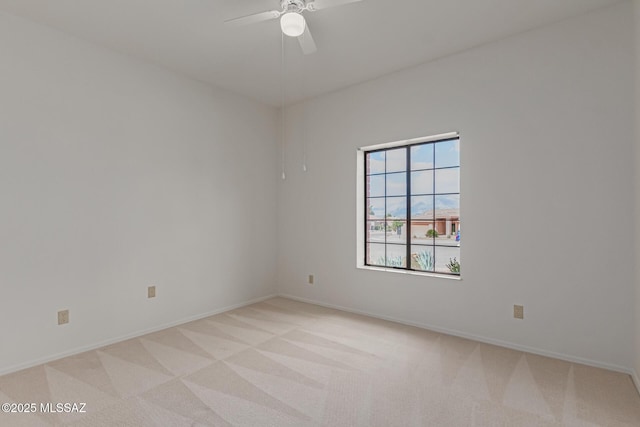 empty room with light colored carpet, baseboards, and ceiling fan