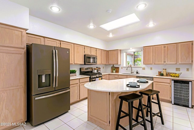 kitchen featuring a sink, appliances with stainless steel finishes, beverage cooler, and light brown cabinets