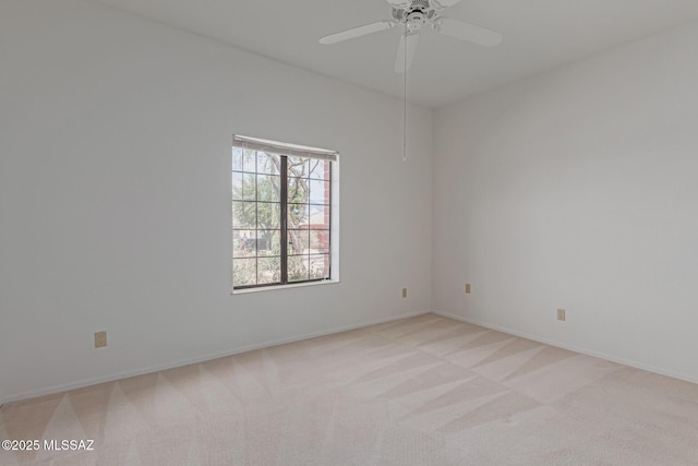 spare room with light carpet, baseboards, and a ceiling fan