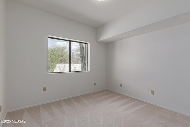 empty room with baseboards and light carpet