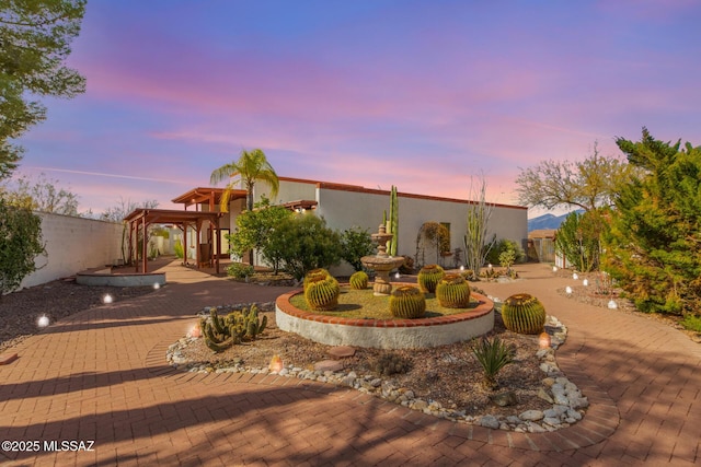 view of front of property featuring fence and stucco siding