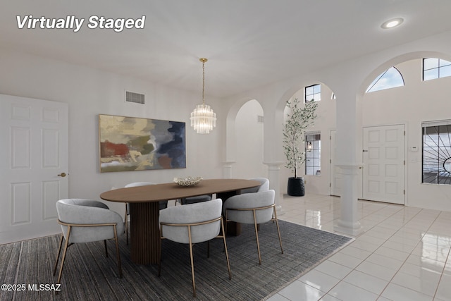 dining area featuring visible vents, light tile patterned flooring, recessed lighting, arched walkways, and a chandelier