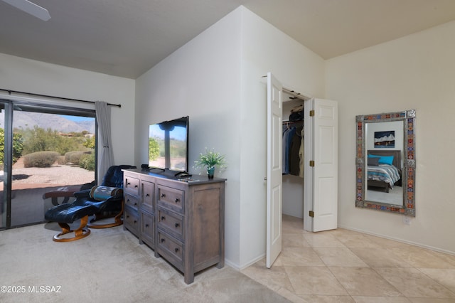 bedroom featuring light tile patterned flooring, a walk in closet, and access to outside