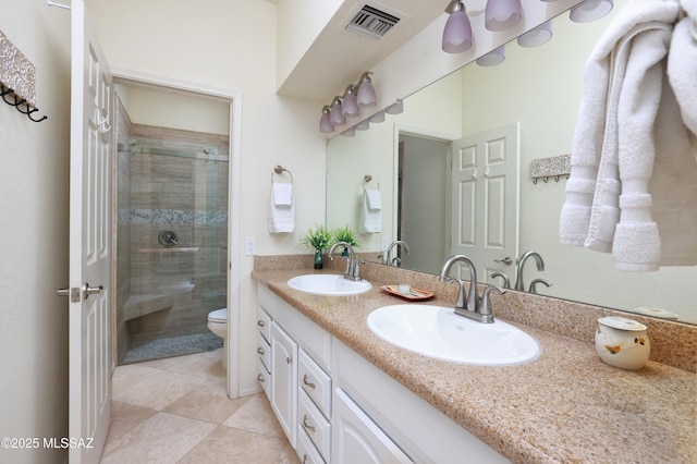 bathroom with vanity, tile patterned flooring, a shower with shower door, and toilet