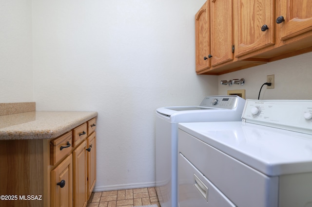 washroom with cabinets and washer and clothes dryer