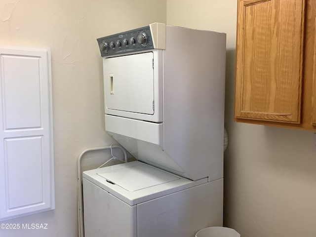 washroom with stacked washing maching and dryer