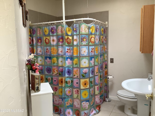 bathroom featuring walk in shower, tile patterned floors, and toilet