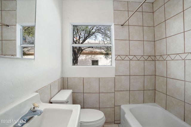 bathroom featuring tile walls, sink, and toilet