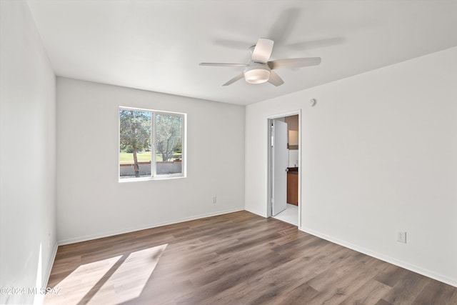 unfurnished room featuring ceiling fan, baseboards, and wood finished floors