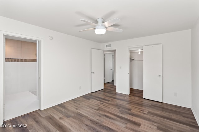 unfurnished bedroom featuring baseboards, visible vents, ceiling fan, and dark wood-type flooring