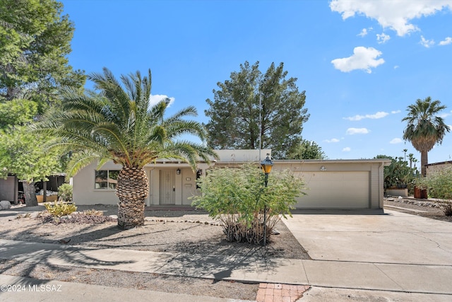 view of front of home featuring concrete driveway, an attached garage, and stucco siding