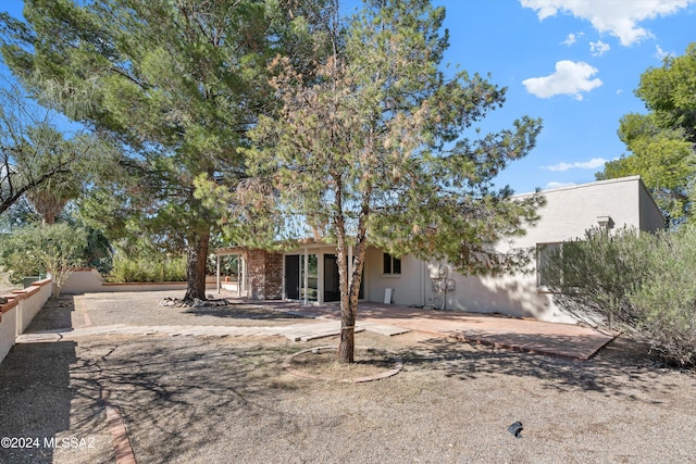 back of house featuring a patio, fence, and stucco siding