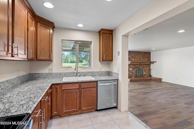 kitchen with light stone counters, electric range oven, open floor plan, a sink, and dishwasher