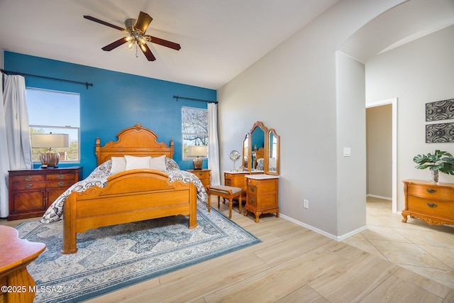 bedroom featuring ceiling fan, lofted ceiling, and light wood-type flooring