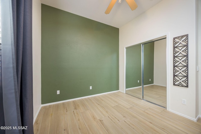 unfurnished bedroom featuring light hardwood / wood-style floors, a closet, and ceiling fan