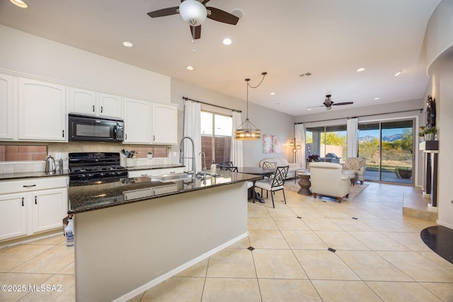 kitchen featuring pendant lighting, sink, dark stone countertops, decorative backsplash, and range