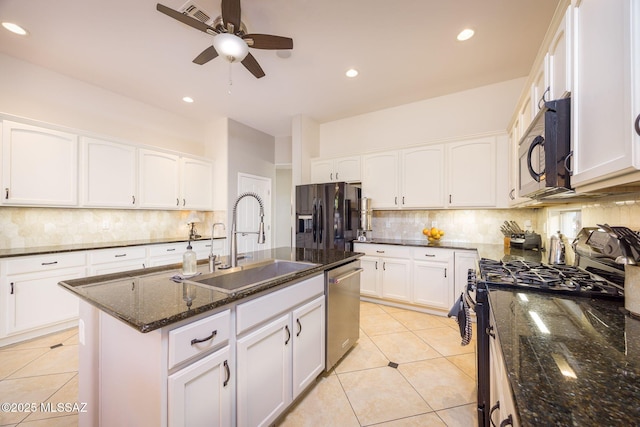 kitchen featuring sink, white cabinets, dark stone counters, and black appliances