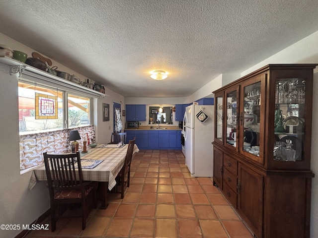 dining space featuring tile patterned floors, sink, and a textured ceiling