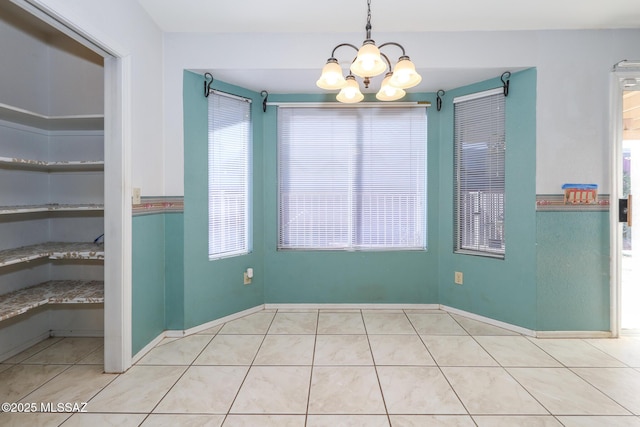 unfurnished dining area with an inviting chandelier and light tile patterned floors