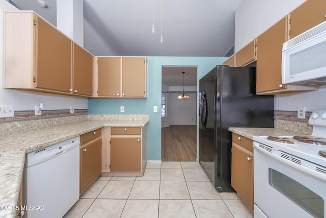 kitchen with light tile patterned flooring, an inviting chandelier, and white appliances