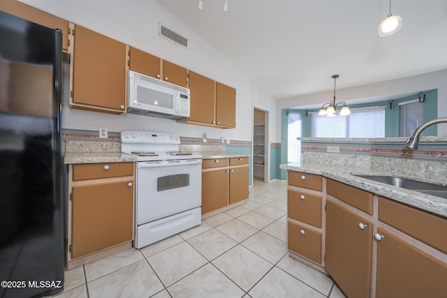 kitchen with lofted ceiling, sink, light tile patterned floors, pendant lighting, and white appliances