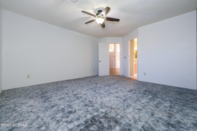 carpeted spare room featuring a textured ceiling and ceiling fan