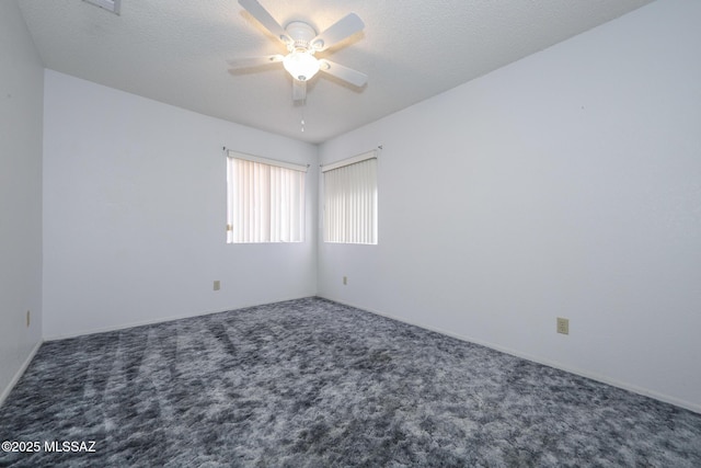 unfurnished room featuring dark carpet and ceiling fan