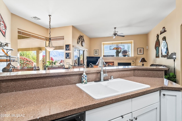 kitchen featuring sink, white cabinets, ceiling fan, and decorative light fixtures