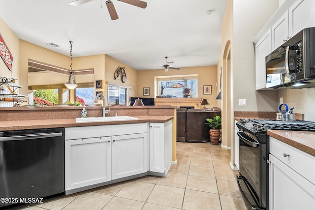 kitchen with hanging light fixtures, white cabinetry, sink, and black appliances