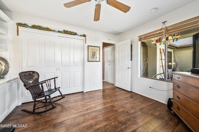 living area with dark wood-type flooring and ceiling fan