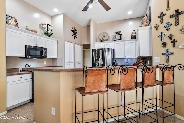 kitchen with white cabinetry, a kitchen breakfast bar, and stainless steel refrigerator with ice dispenser