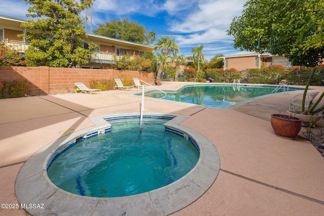 view of swimming pool featuring a hot tub and a patio