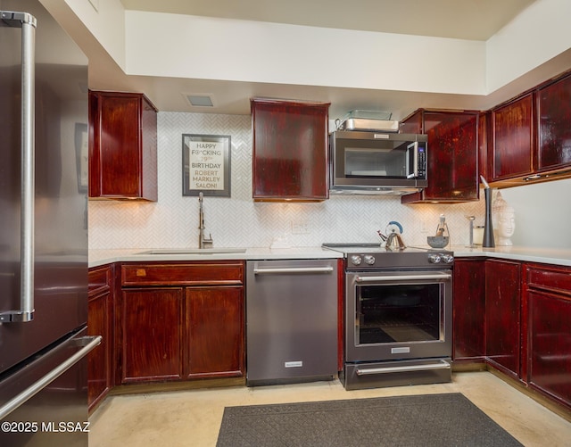 kitchen featuring high quality appliances, sink, and backsplash