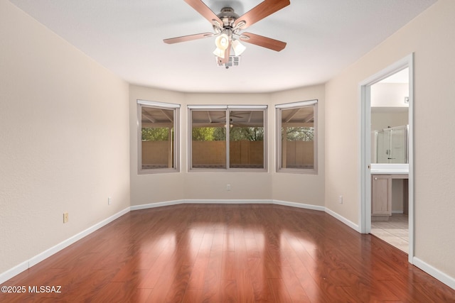 spare room with dark hardwood / wood-style floors and ceiling fan