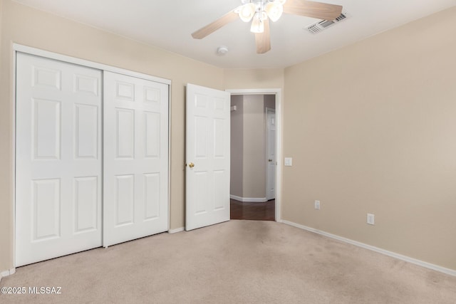 unfurnished bedroom featuring light colored carpet, a closet, and ceiling fan