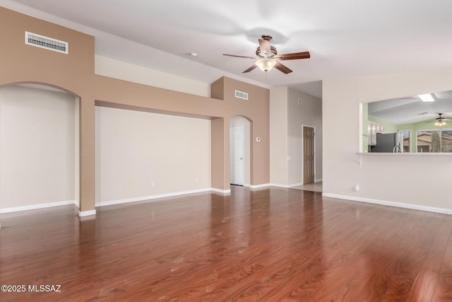 spare room with dark hardwood / wood-style flooring, vaulted ceiling, and ceiling fan