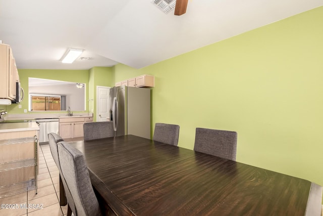 unfurnished dining area with ceiling fan, lofted ceiling, sink, and light tile patterned floors