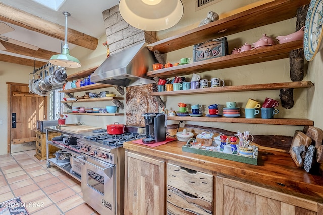 interior space with stainless steel appliances, decorative light fixtures, butcher block countertops, and range hood