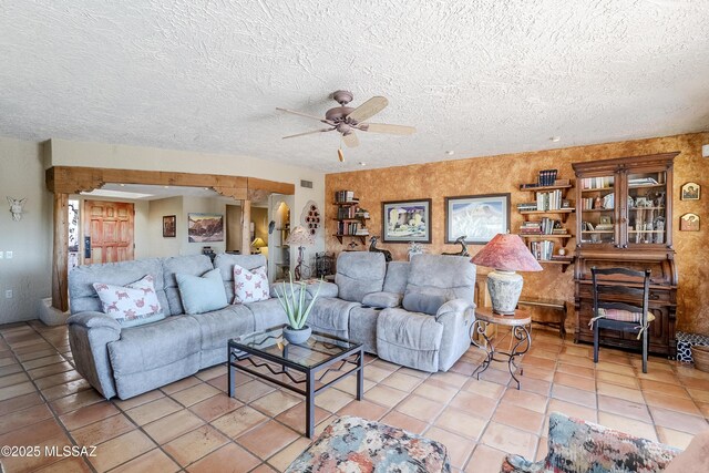 living room with a textured ceiling, tile patterned floors, and ceiling fan