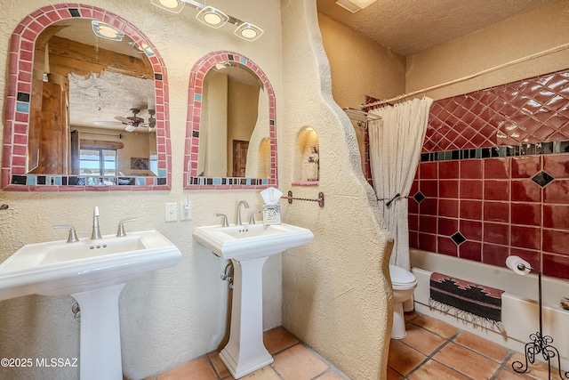 full bathroom with ceiling fan, toilet, a textured ceiling, and shower / bath combo