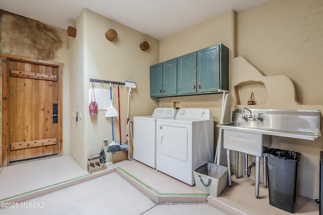 clothes washing area with cabinets and washer and dryer