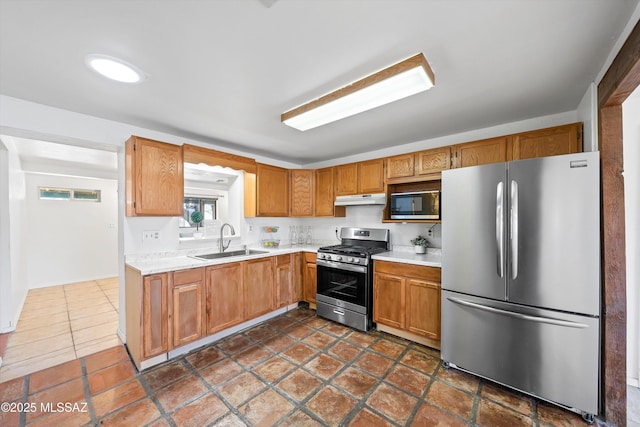 kitchen featuring stainless steel appliances, sink, and dark tile patterned floors