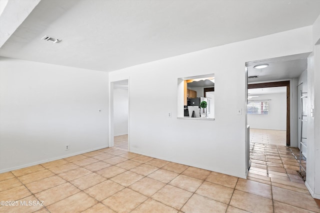 spare room featuring light tile patterned flooring