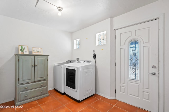 laundry room with tile patterned flooring, washing machine and dryer, and cabinets